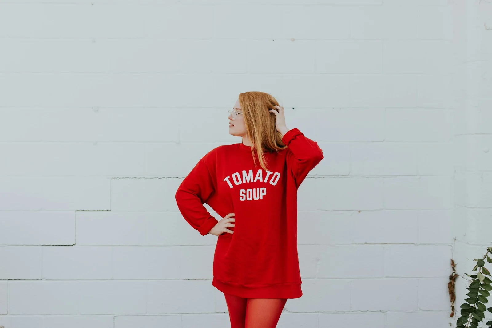 A woman in a red graphic sweatshirt stands with her back to the camera