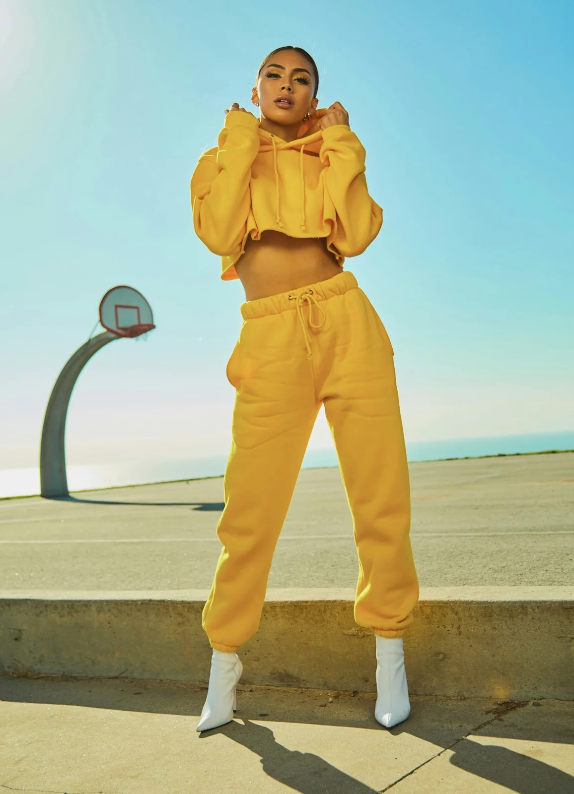 A woman wears a bright yellow cropped top and matching loose trousers